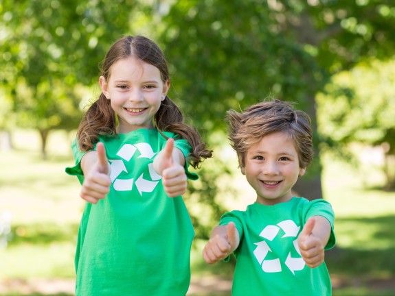 Two children in green shirts with thumbs up